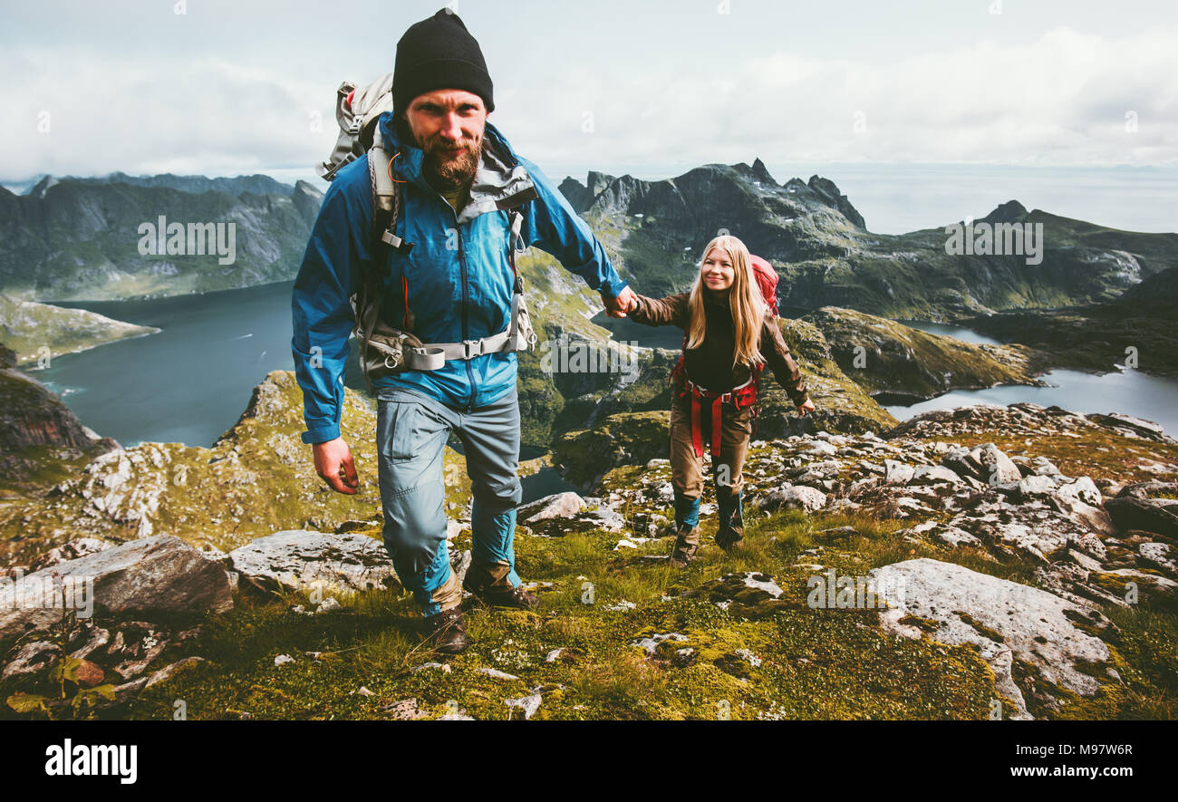Backpackers Couple holding hands hiking in mountains Travel Lifestyle wanderlust concept family together spending active adventure vacations Stock Photo