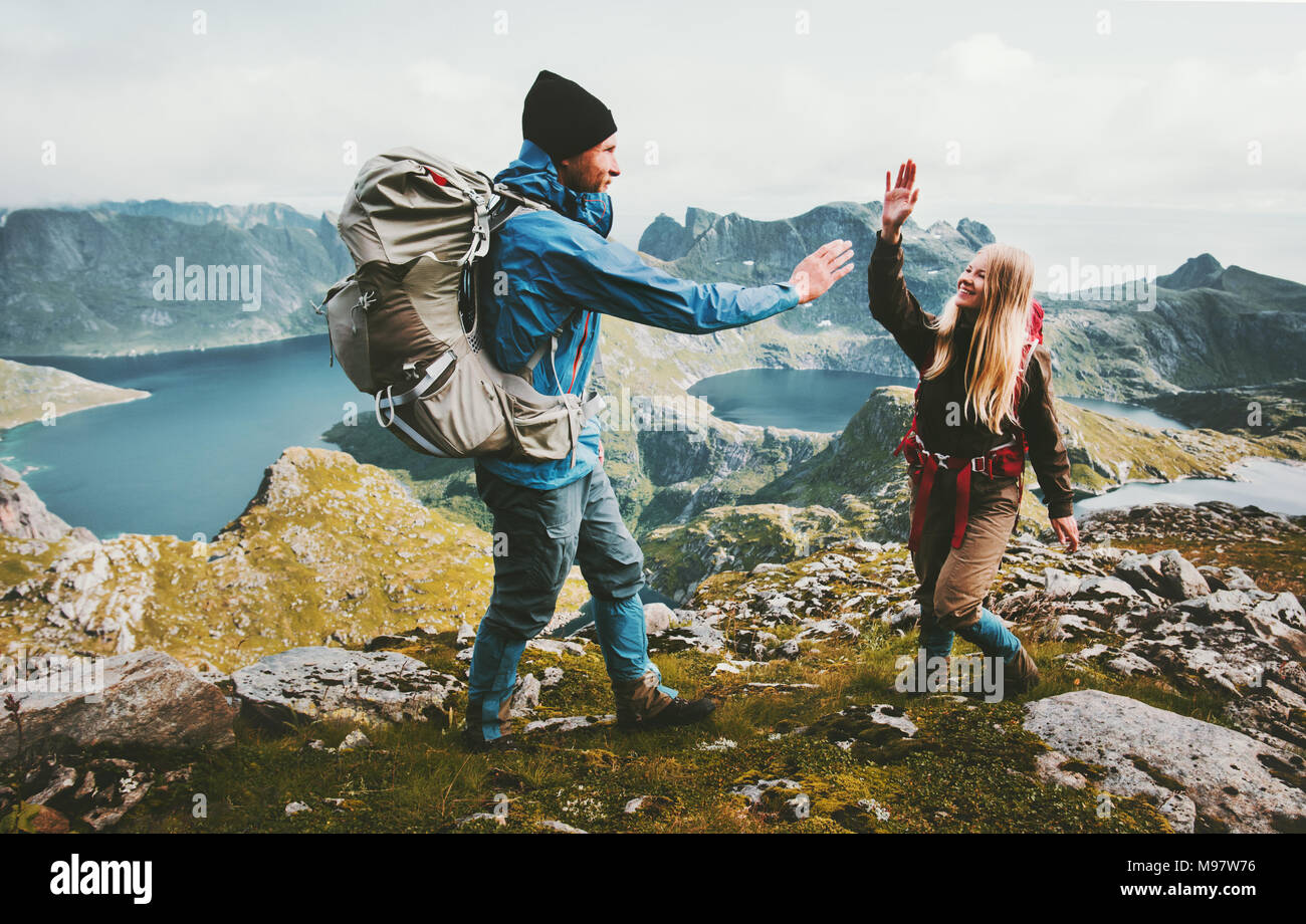Happy couple in love giving five hands on the top of mountain Travel Lifestyle joy emotions concept family backpackers together adventure vacations Stock Photo