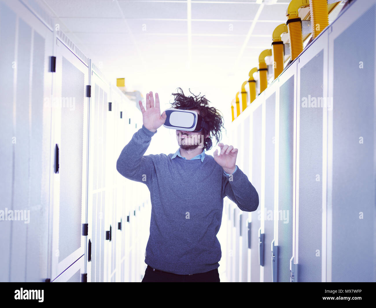 young IT engeneer using virtual reality headset over server room background Stock Photo