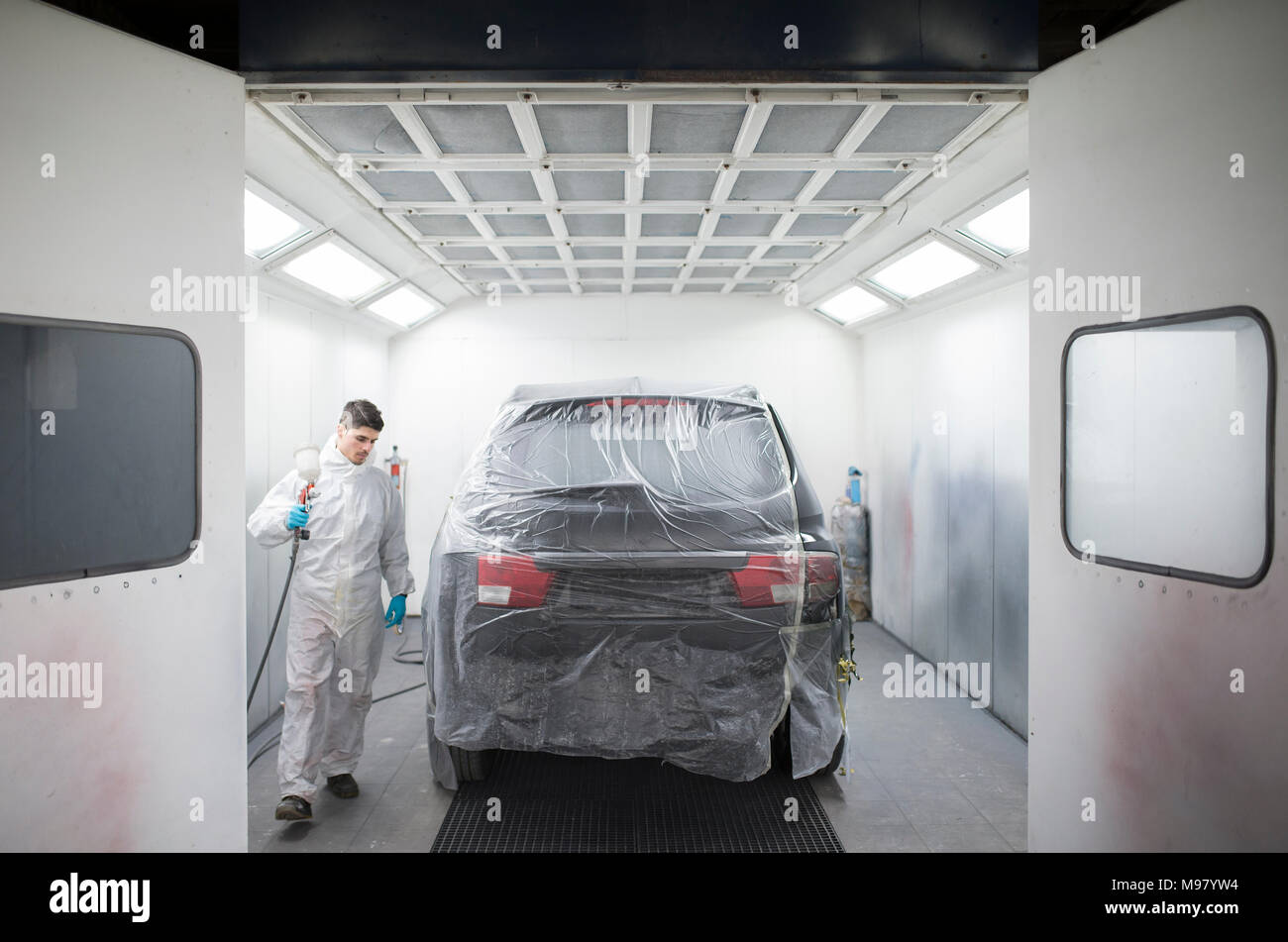 Auto painter painting a car inside a paint booth Stock Photo Alamy