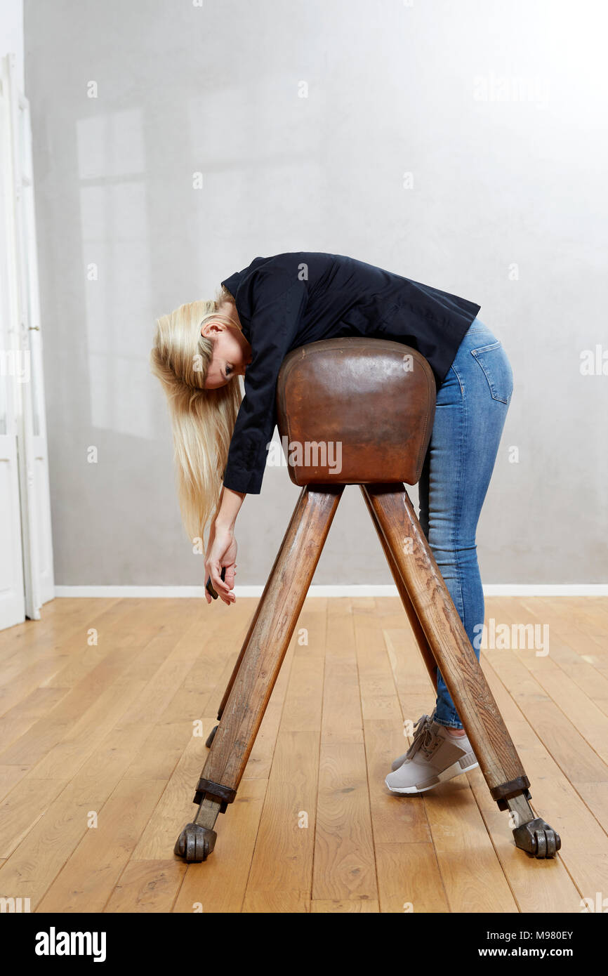 Woman leaning on pommel horse Stock Photo