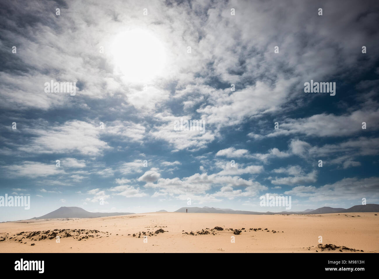 Spain, Canary Islands, Fuerteventura, Parque Natural de Corralejo, small person standing on dune Stock Photo