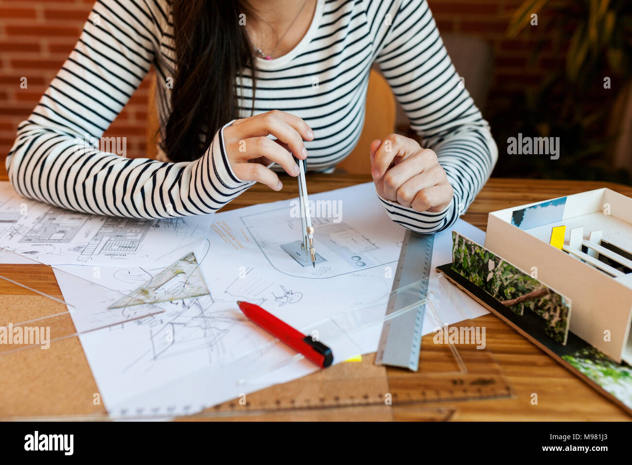 Young woman working in architecture office, drawing blueprints Stock Photo