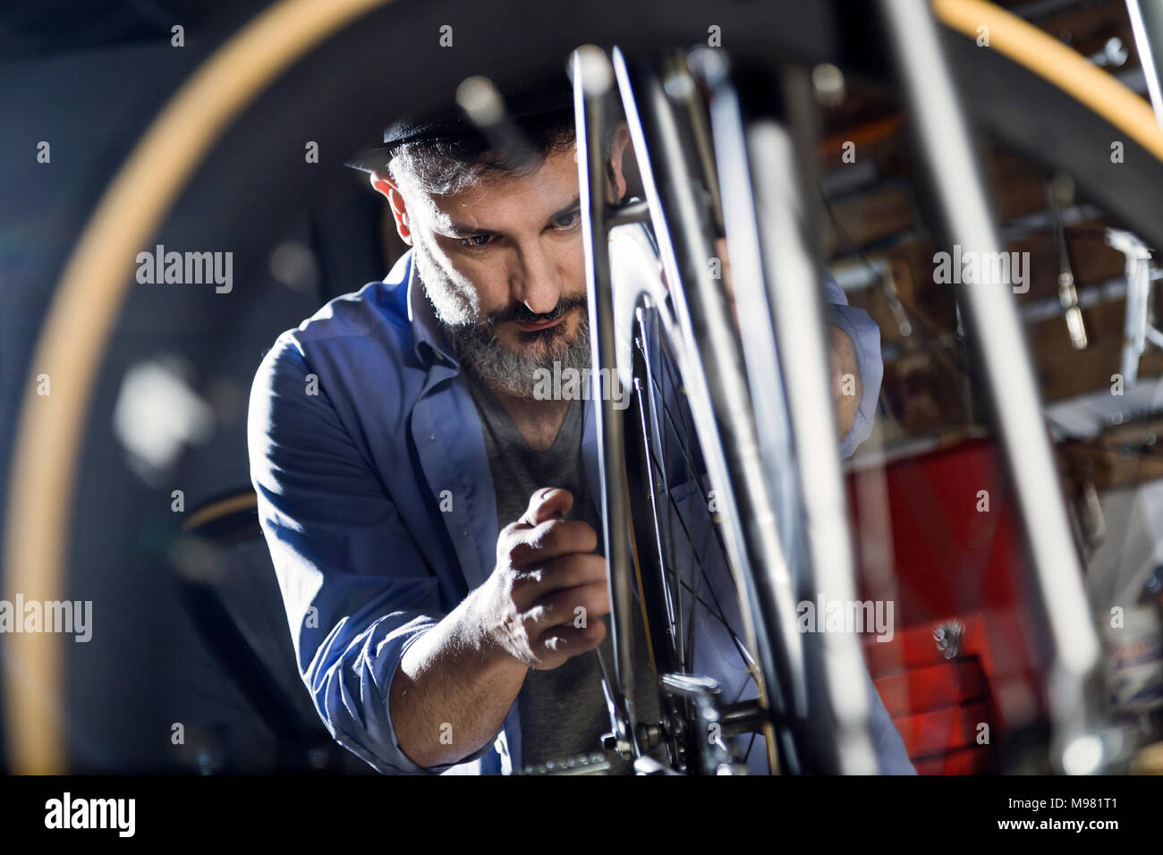 Man working on bicycle in workshop Stock Photo