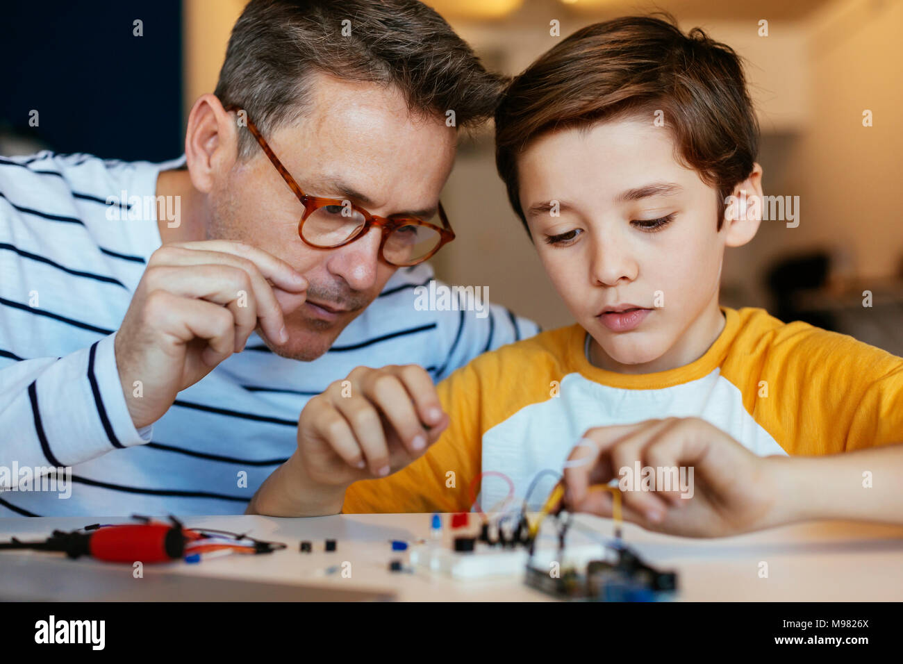 Father and son assembling an electronic construction kit Stock Photo
