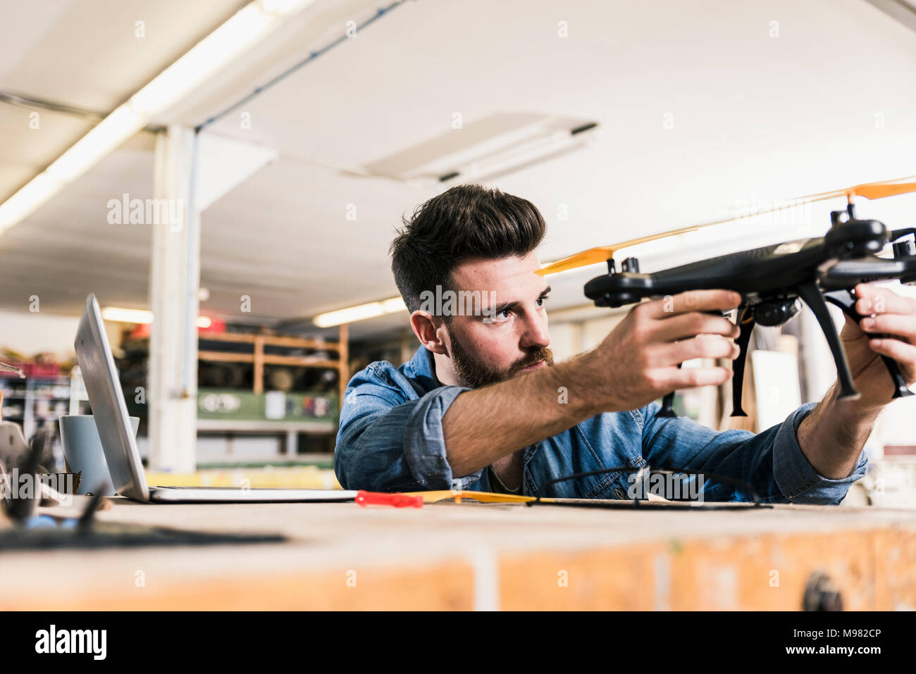 Man working on drone in workshop Stock Photo