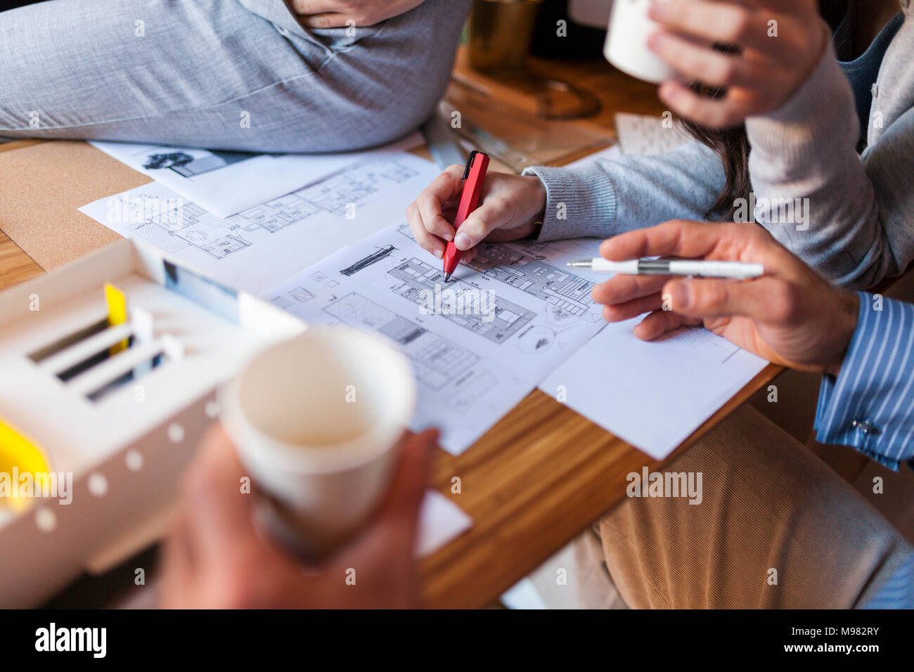 Team of architects working on a project, discussing blueprints Stock Photo