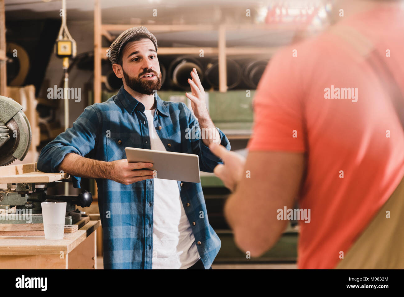 Two men with tablet discussing in workshop Stock Photo