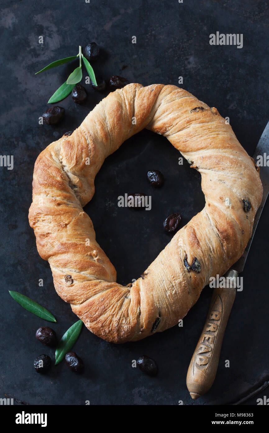 Ring bread with black olives, bread knife and black olives on metal Stock Photo