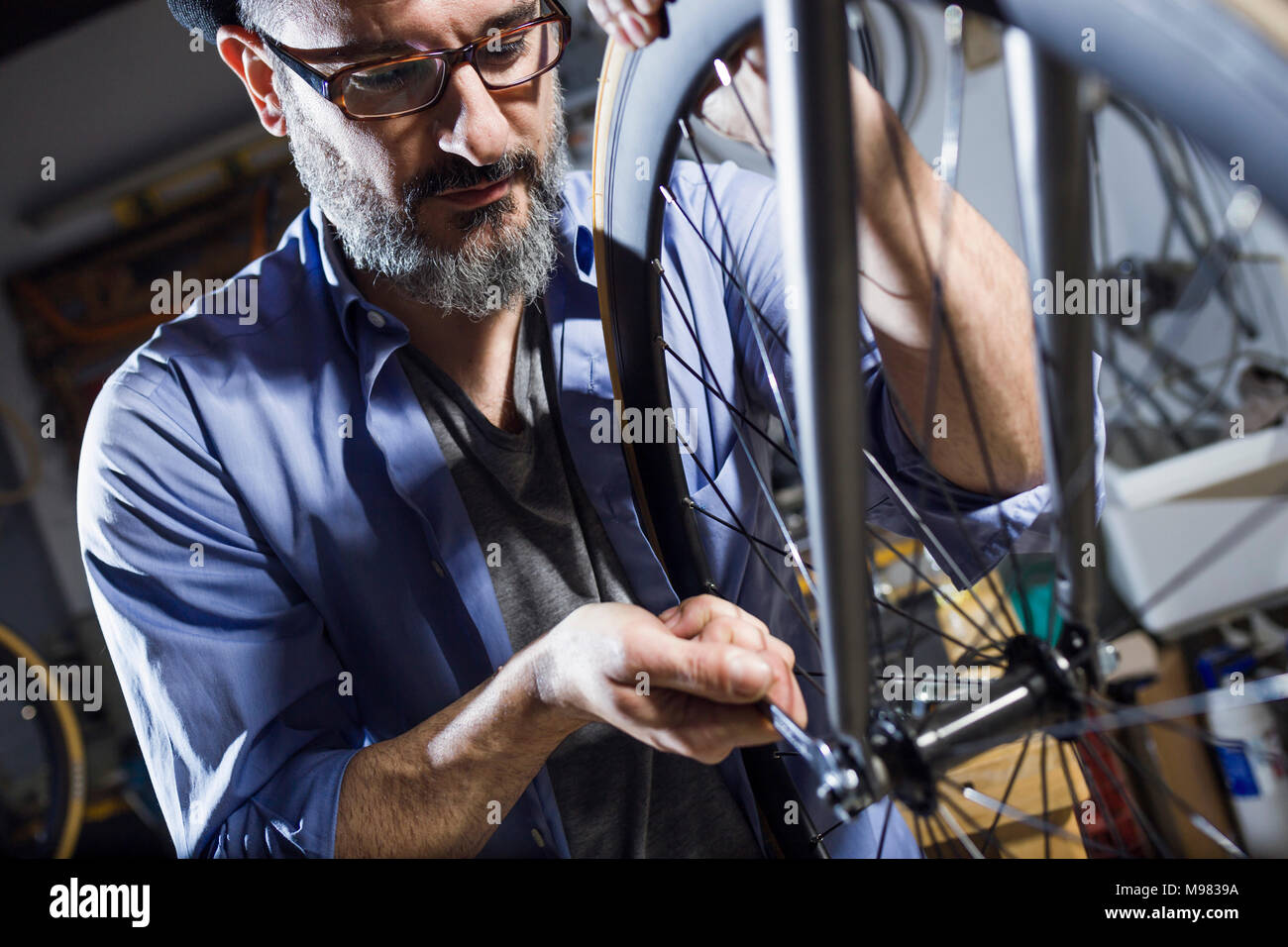 Man working on bicycle in workshop Stock Photo