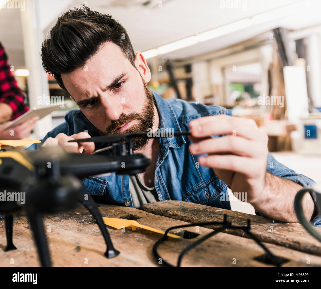 Man working on drone in workshop Stock Photo