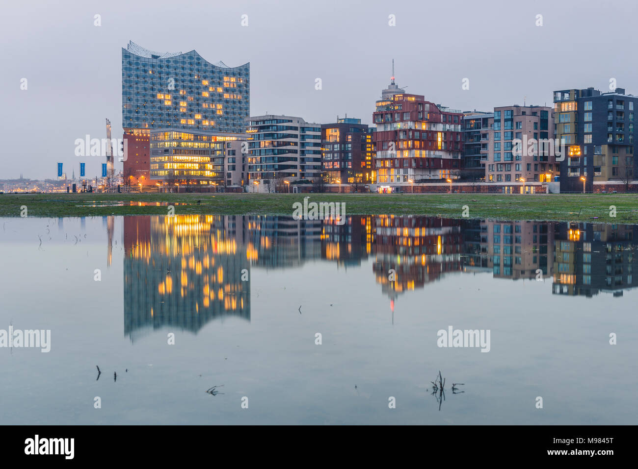 Germany, Hamburg, Hafencity, modern buildings and Elbe Philharmonic Hall in the evening Stock Photo