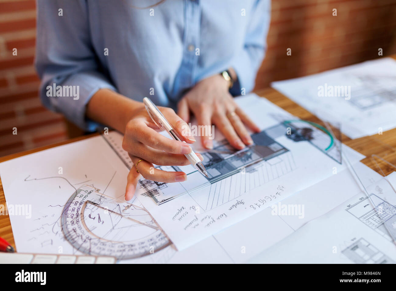 Young woman working in architecture office, drawing blueprints Stock Photo