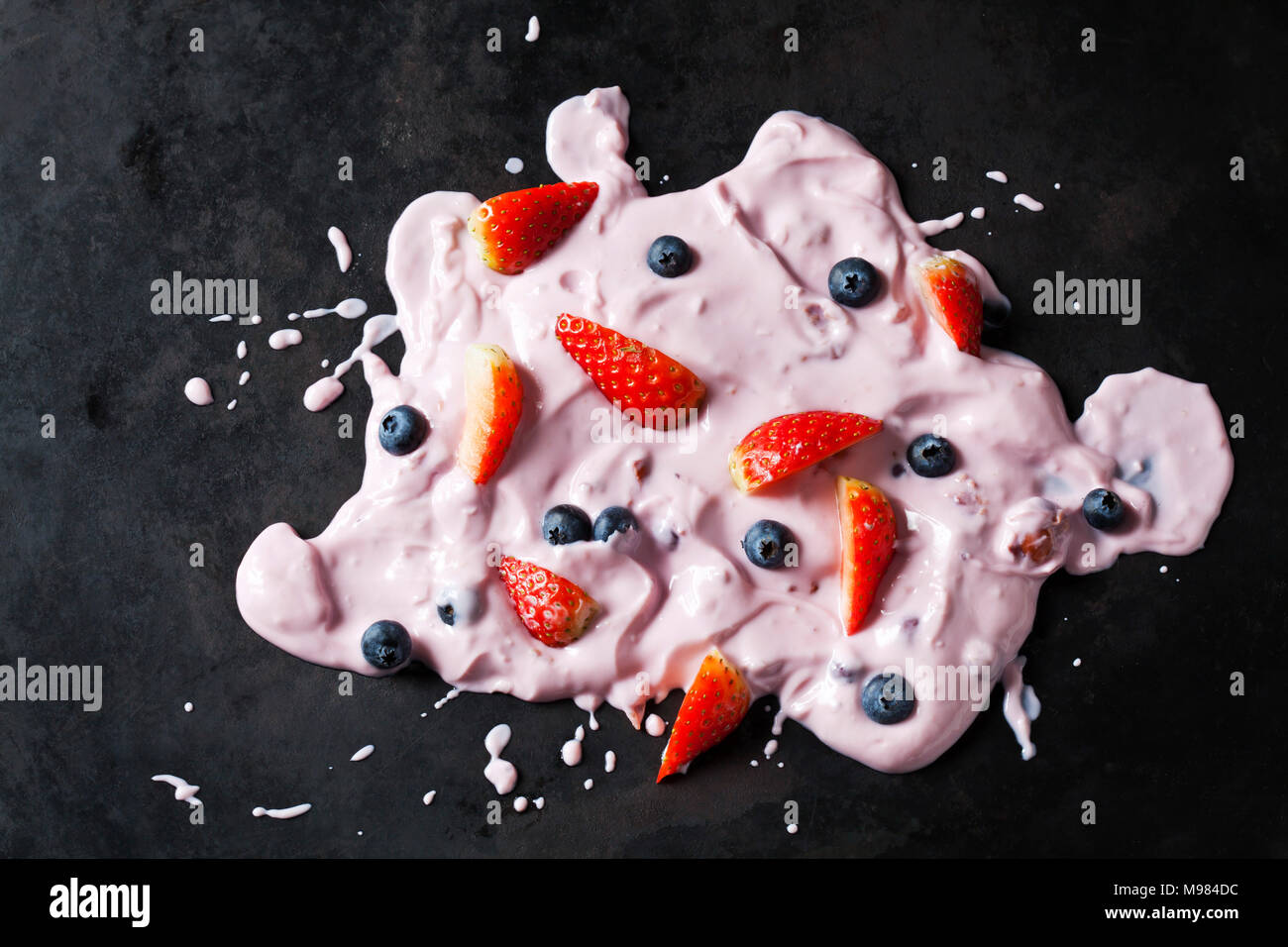 Strawberry yoghurt with strawberries and blueberries on dark ground