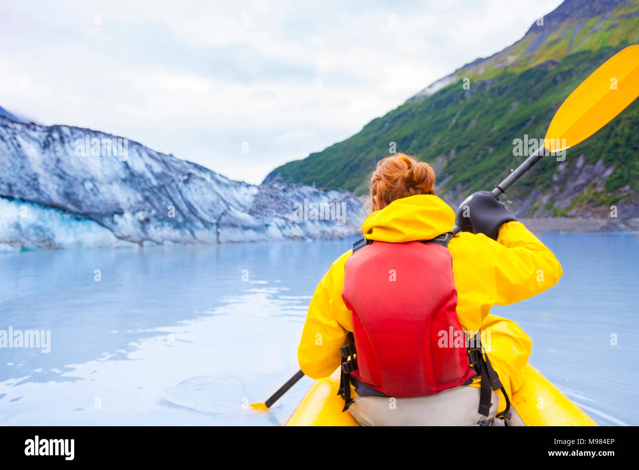 USA, Alaska, Valdez, young woman in kayak in front of Valdez Glacier ...