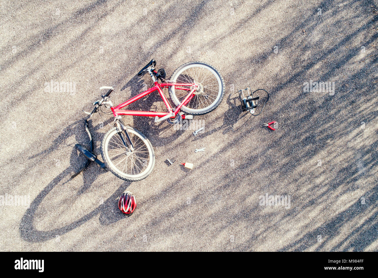 Bicycle, cycling helmet and repair tools on tarmac Stock Photo