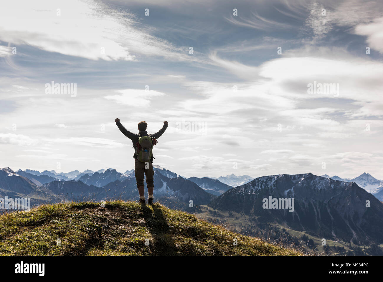 Austria, Tyrol, young man standing in mountainscape cheering Stock Photo