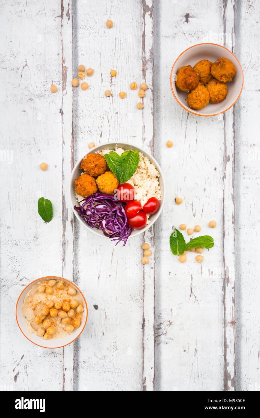 Sweet potato balls, Couscous, Hummus and vegetables in bowls Stock