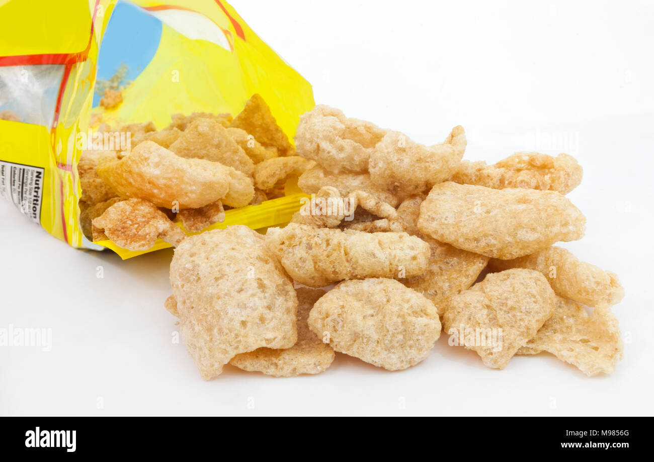 Pork rinds or chicharones spilling from open snack bag. Stock Photo