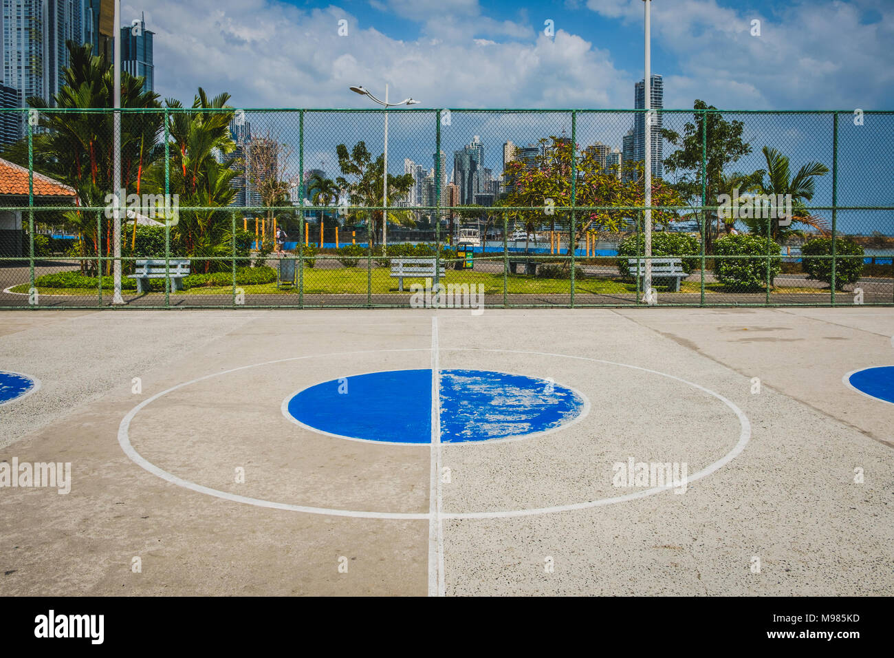 basketball court center circle with park and skyline background - Stock Photo