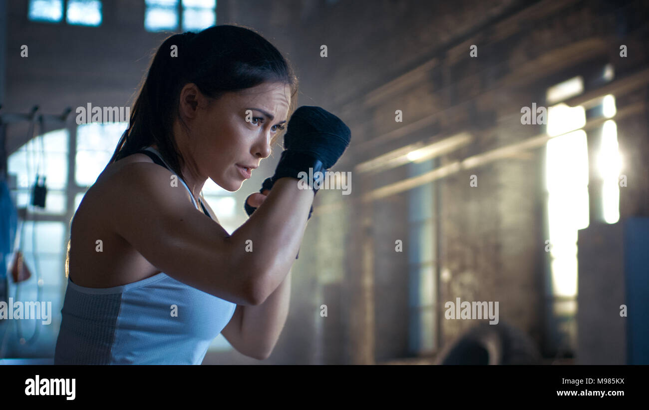 Young beautiful lady doing abs workout functional crossfit training on  punching bag. Strong muscular sporty girl ready for active exercise in  sport gym. Strength and motivation. Self defense training. Stock Photo