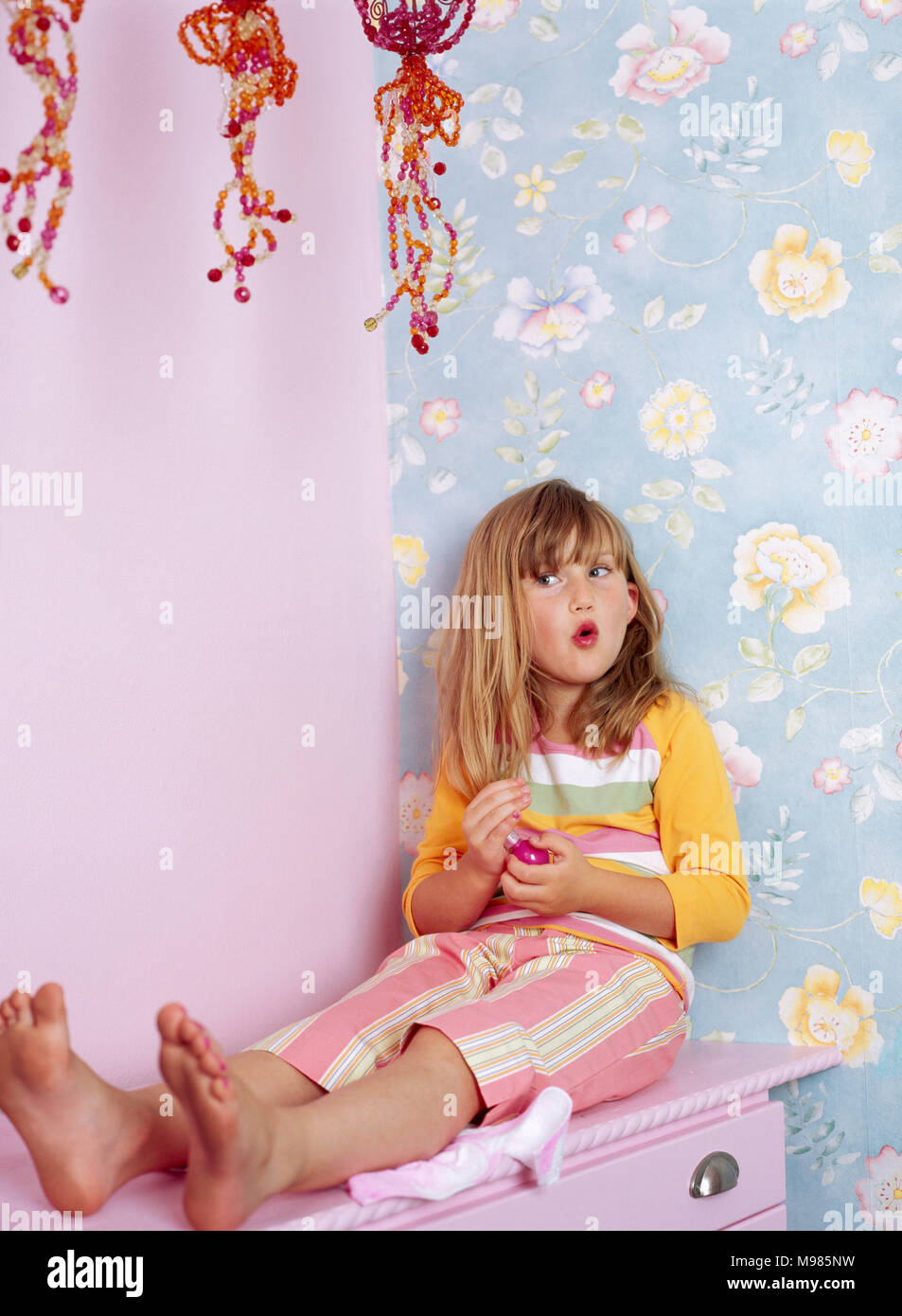 barefoot little girls Portrait of little girl with red lips sitting barefoot on pink chest of  drawers Stock Photo - Alamy