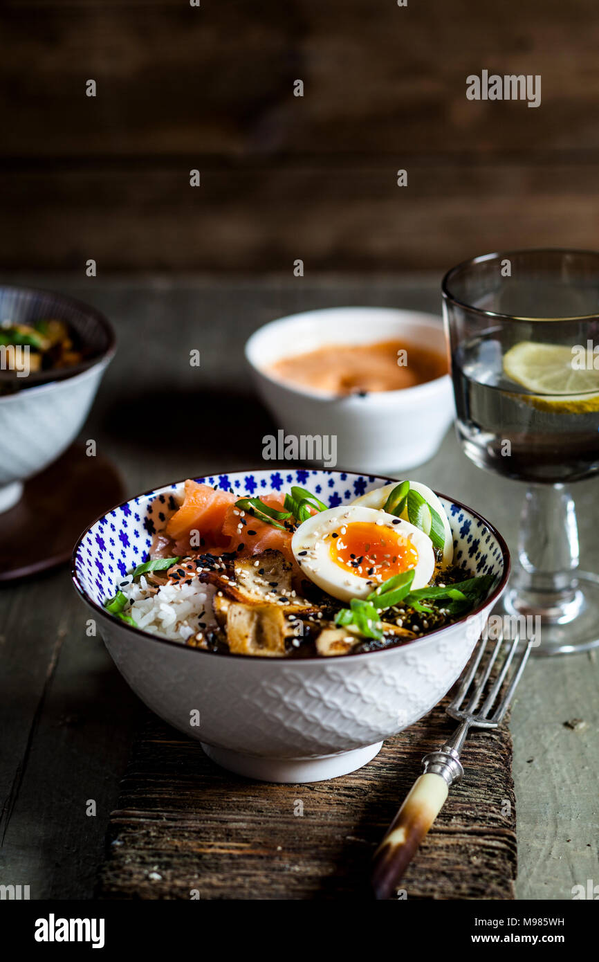 Lunch bowl, cooked egg, rice, smoked salmon, mushroom, green cabbage, sesame Stock Photo