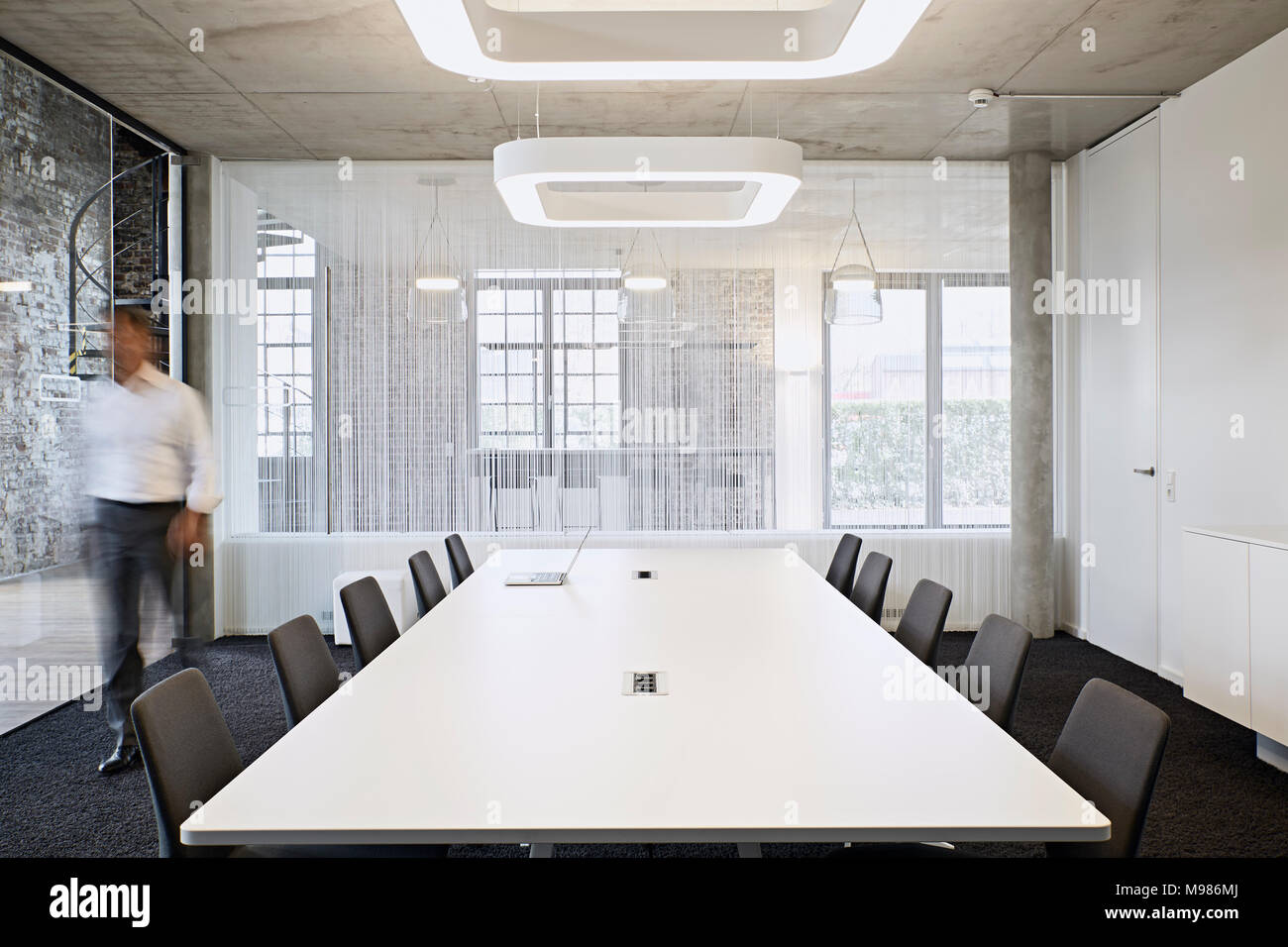 Businessman walking in modern conference room Stock Photo