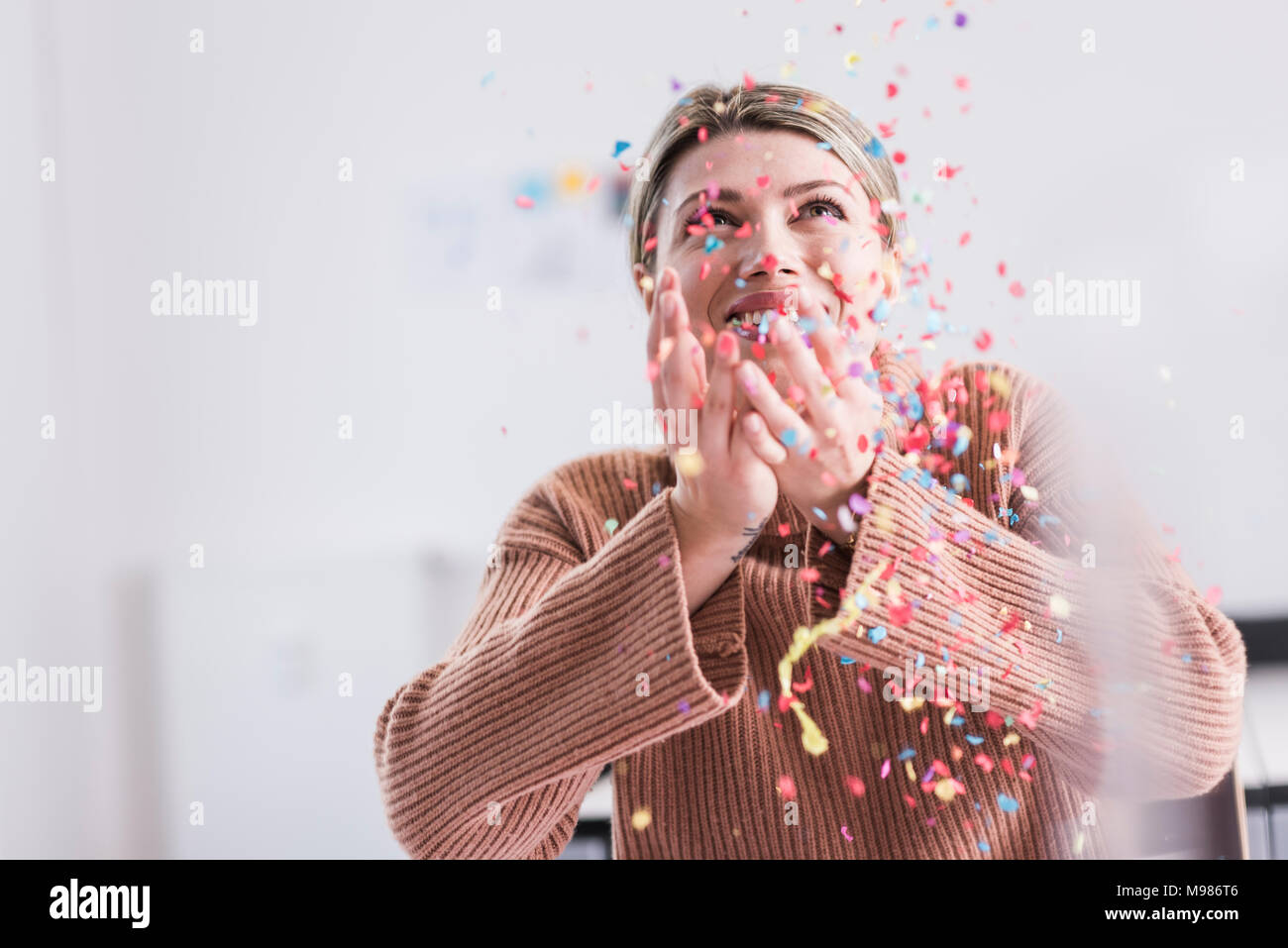 Happy young woman throwing confetti in the air Stock Photo Alamy