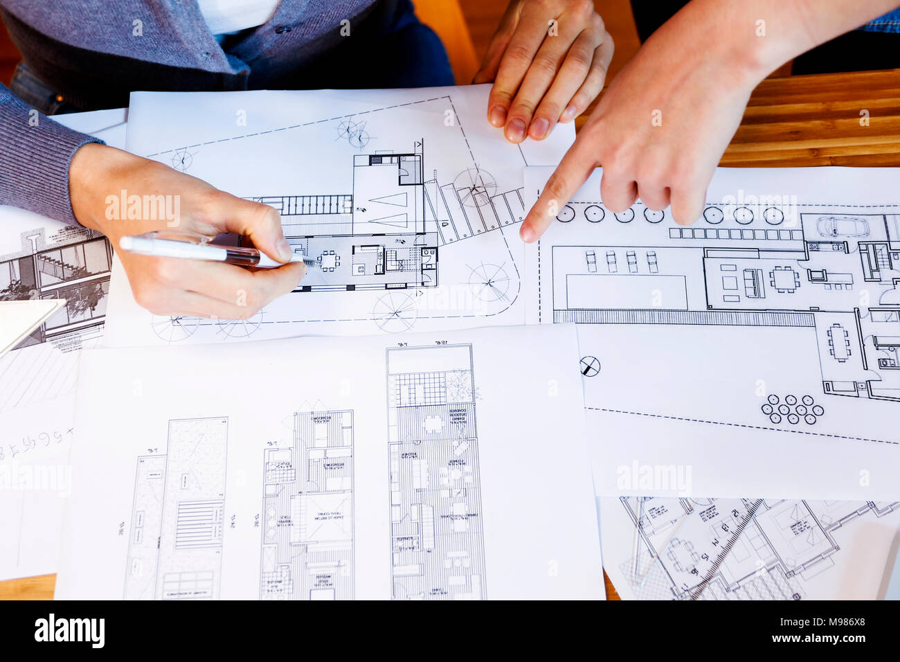 Team of architects working on a project, discussing blueprints Stock Photo