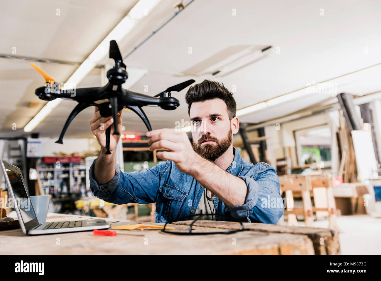 Man working on drone in workshop Stock Photo