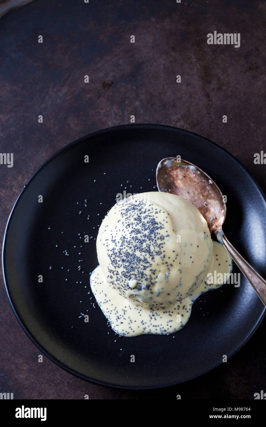 Yeast dumpling with vanilla sauce and poppy seed on plate Stock Photo