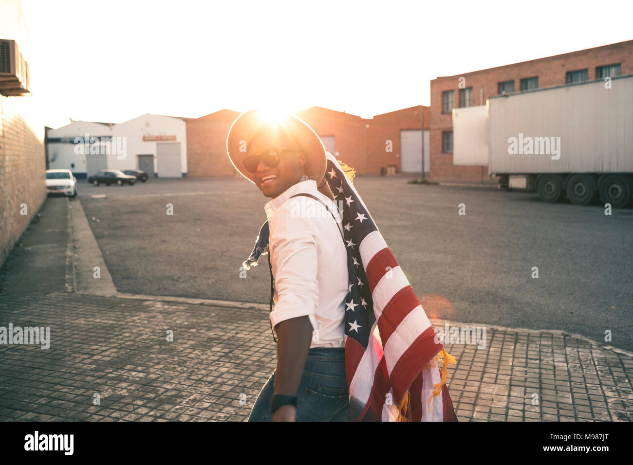 Laughing young man with American flag at backlight Stock Photo