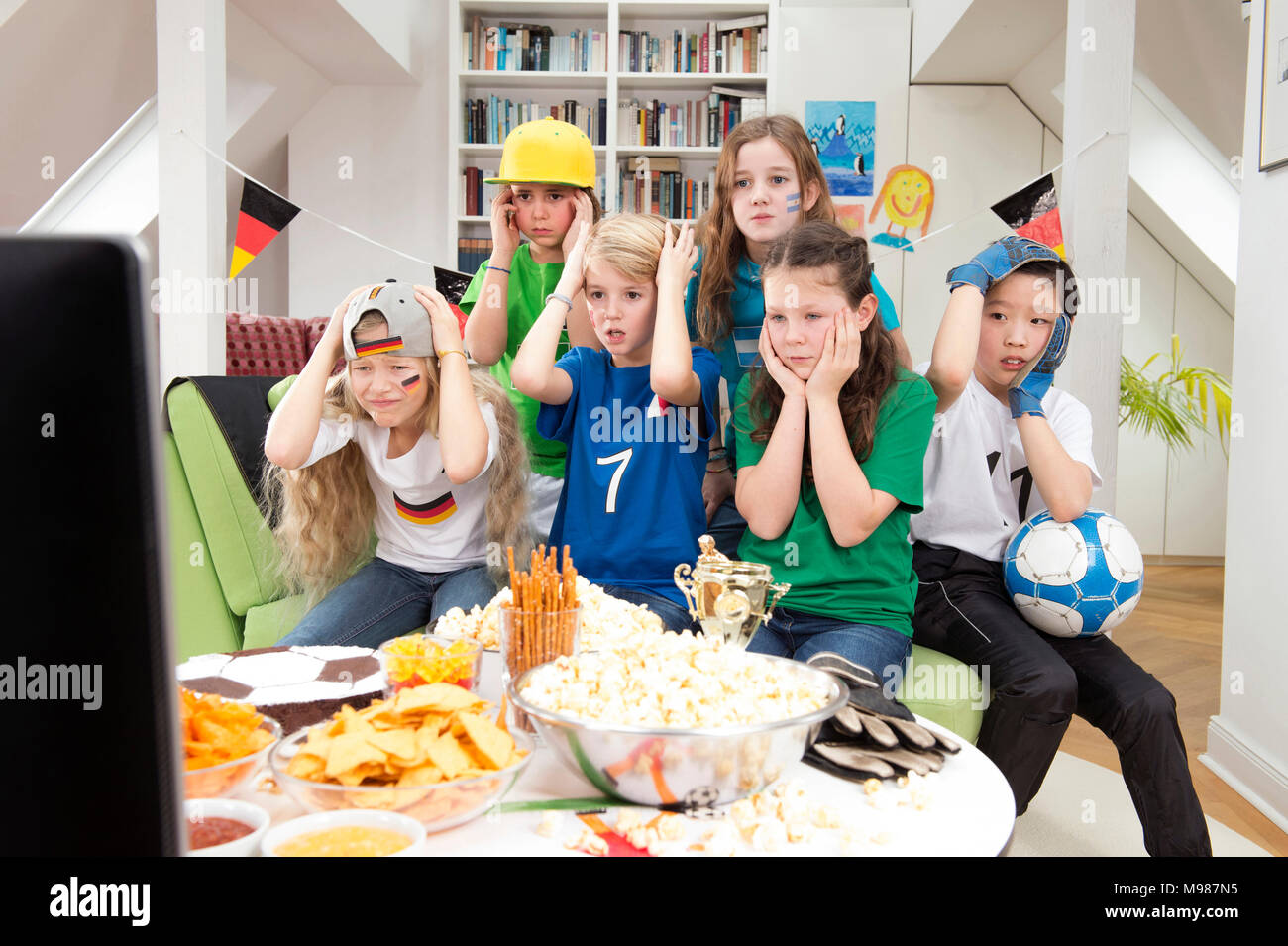 Group Of Kids Watching Soccer World Championship With Table Full