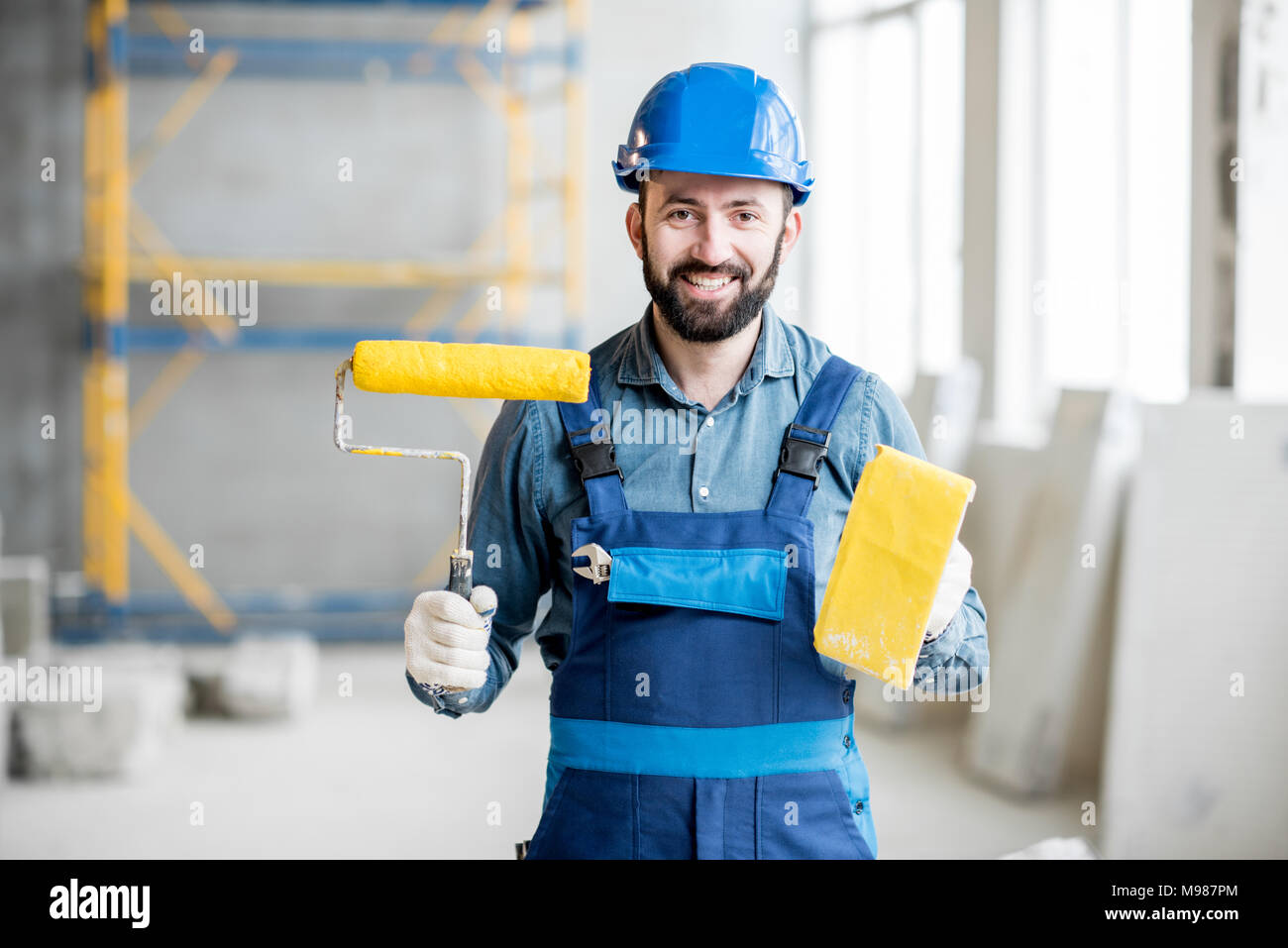 Builder with paint roll indoors Stock Photo Alamy