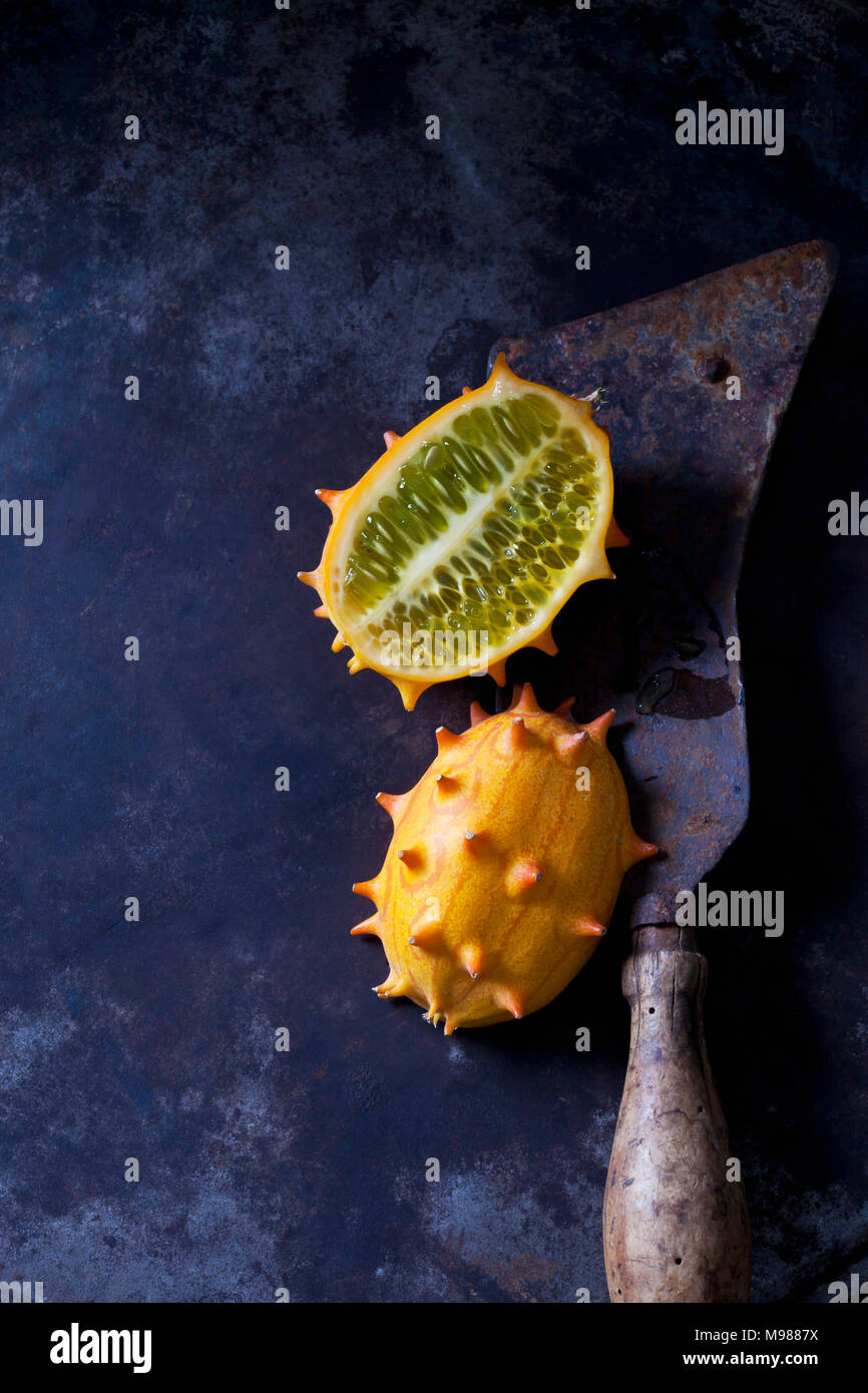 Sliced kiwano and cleaver on rusty metal Stock Photo