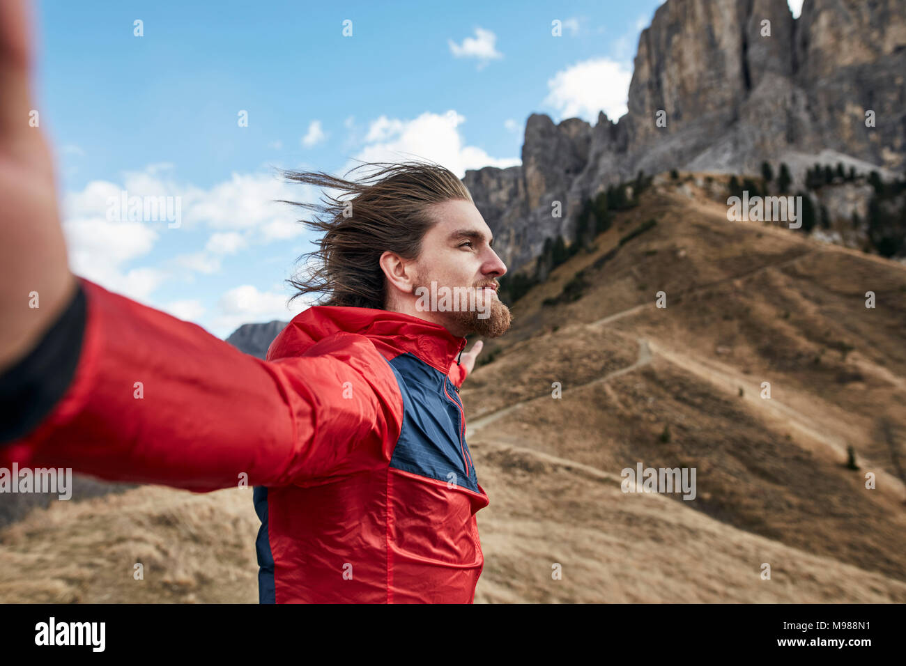 Young man leaning against the wind in the mountains Stock Photo Alamy