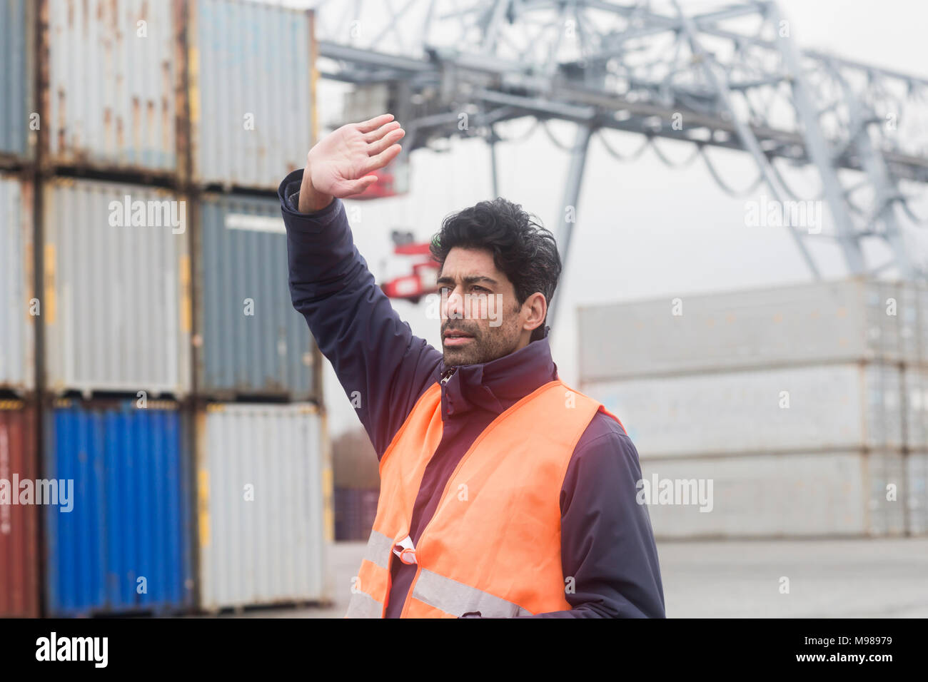 Man wearing reflective vest working at container port Stock Photo