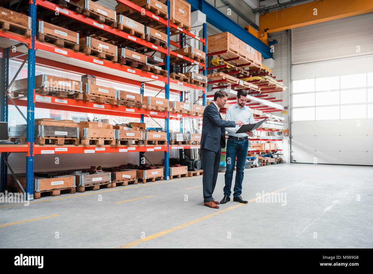 Two men walking and talking in factory shop floor Stock Photo - Alamy