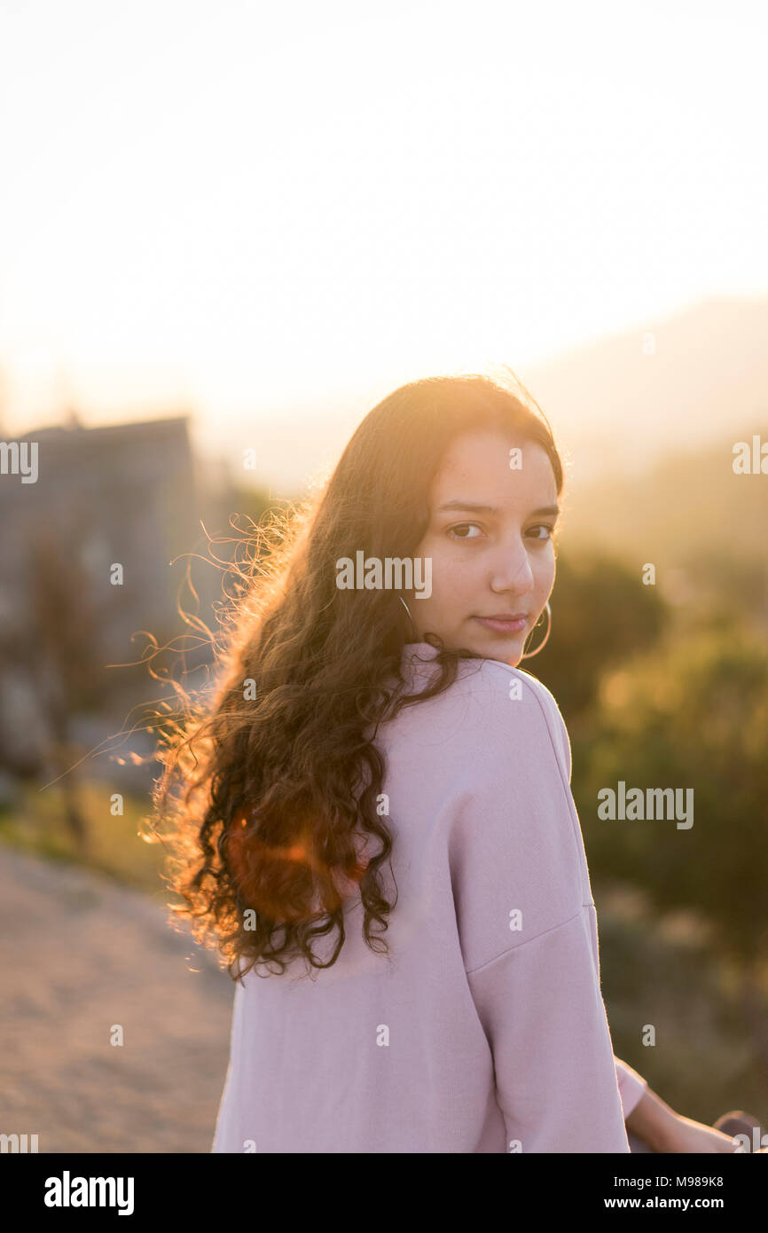 Portrait of young woman with long curly hair at sunset Stock Photo - Alamy
