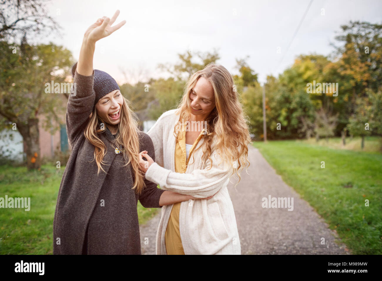 Two happy women walking in rural landscape Stock Photo - Alamy