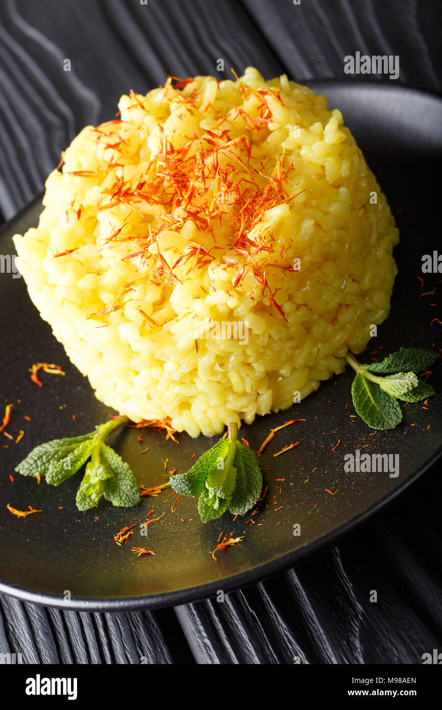 Italian risotto alla milanese with saffron closeup on a plate on a
