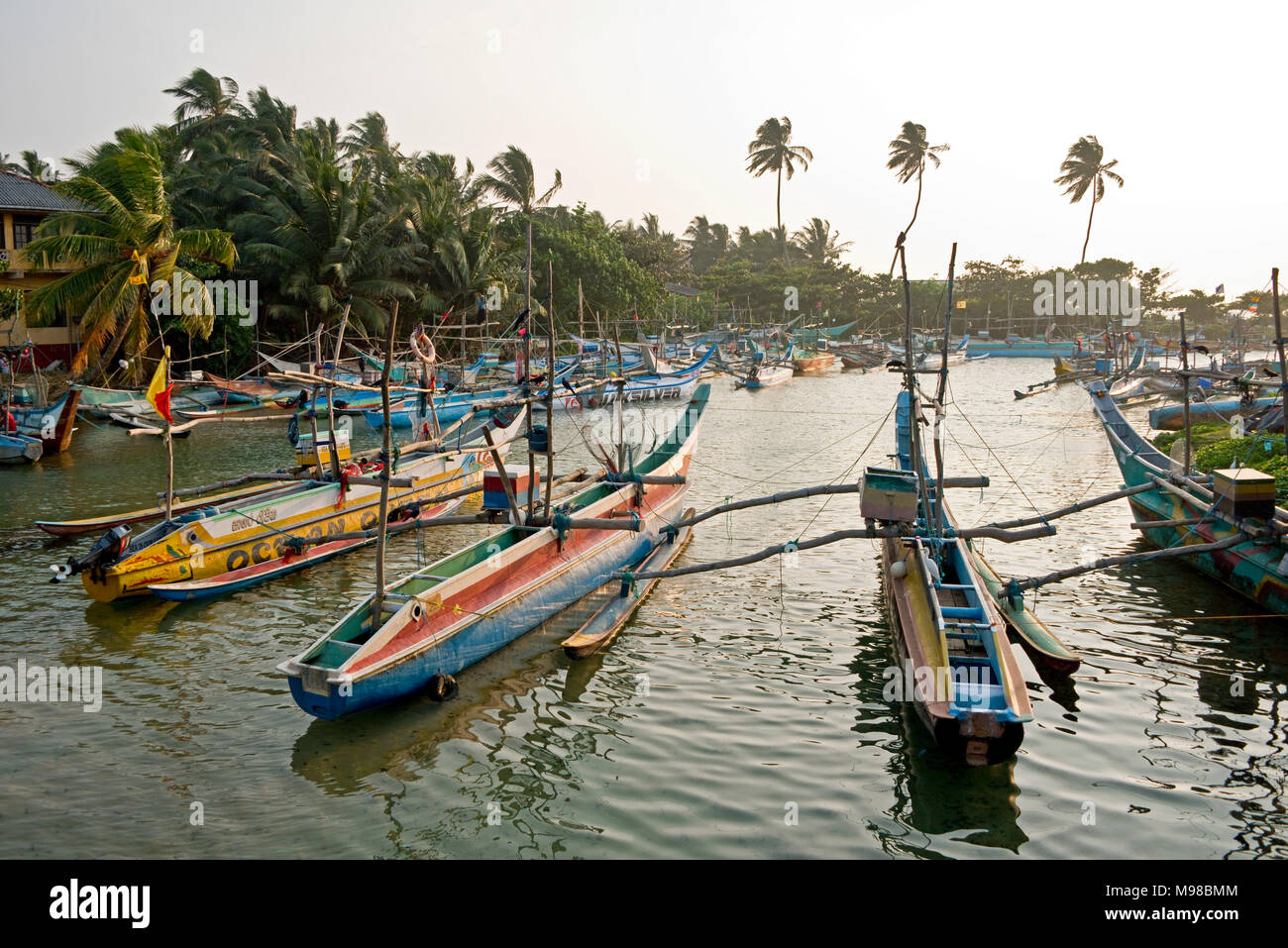 Fishing harbour in Dodanduwa - a small fishing village near Hikkaduwa in Sri Lanka with colourful traditonal fishing boats and taken contre jour. Stock Photo