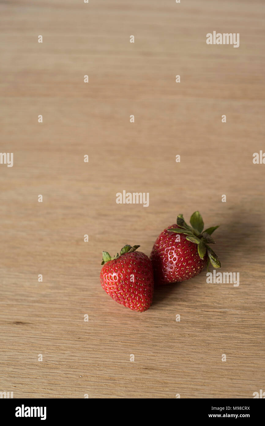 Two Strawberries on a Wooden Counter Stock Photo