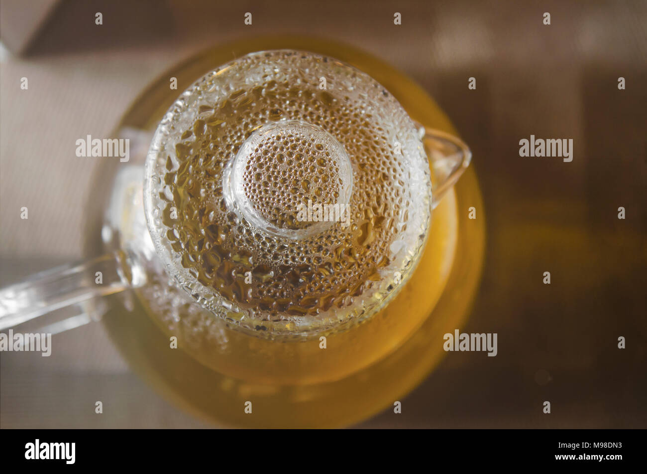 glass teapot with tea with water drops on the lid Stock Photo