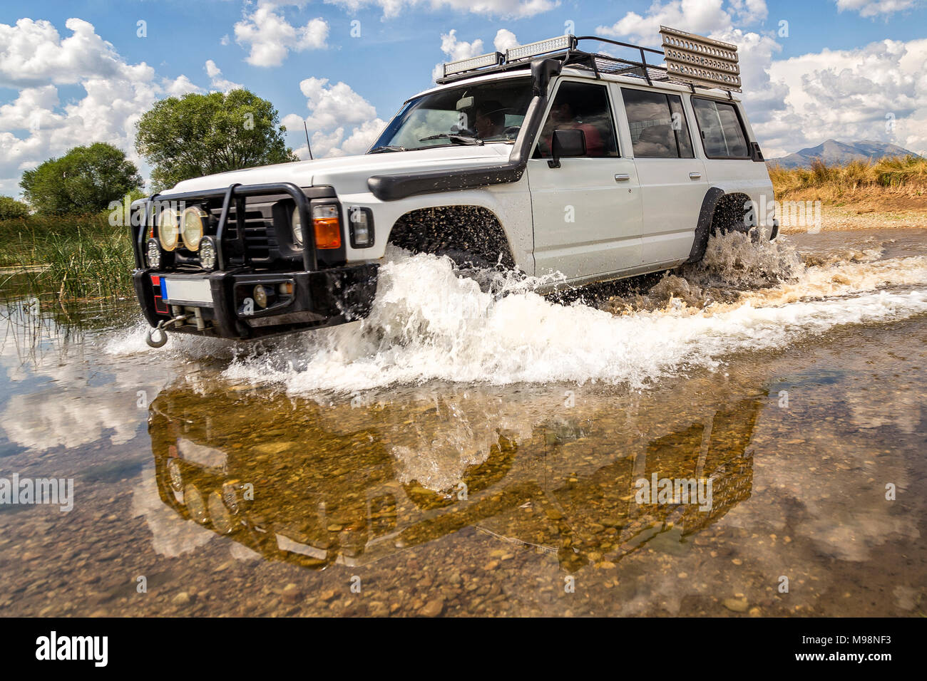 Off-road vehicle crossing river Stock Photo