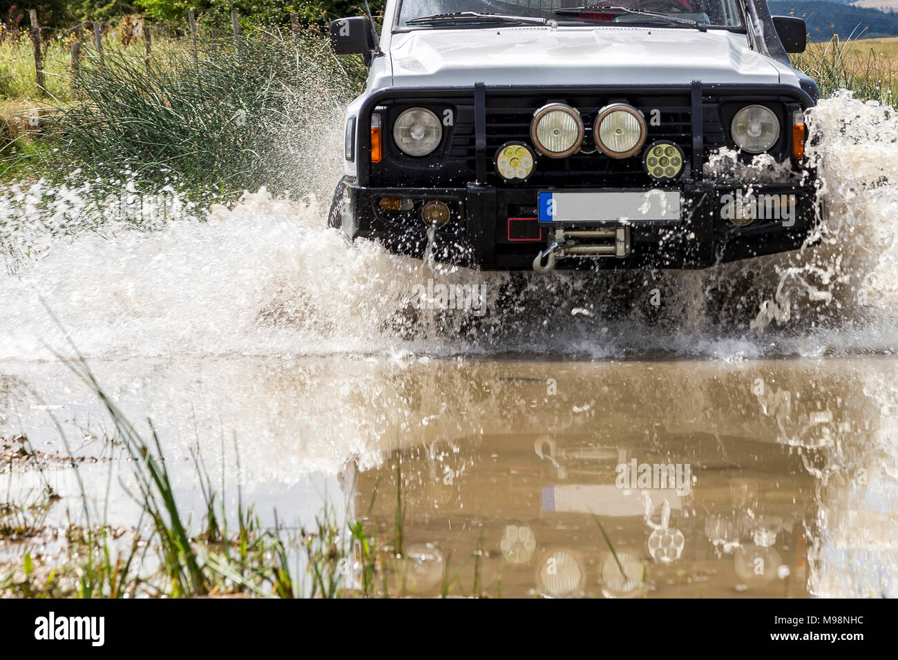 Off-road vehicle crossing river Stock Photo