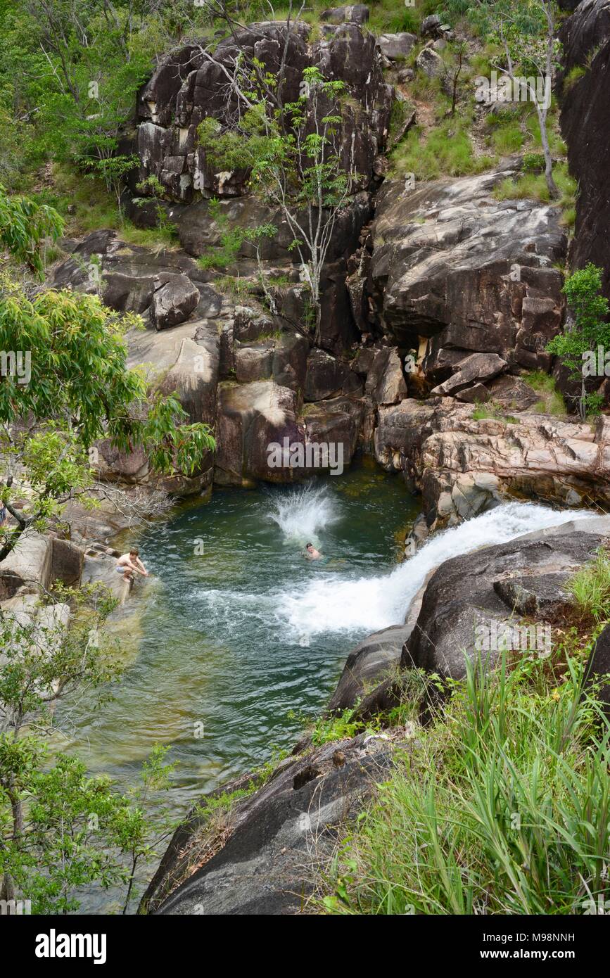 People jumping into a cool pool with a waterfall at the rockslides at big Crystal Creek QLD 4816, Paluma range national park, Australia Stock Photo