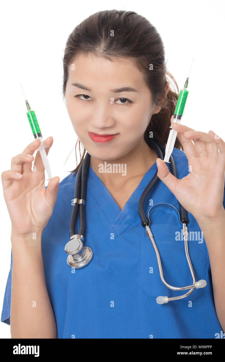 Evil Asian doctor or nurse holding a syringe filled with green medication isolated on a white background Stock Photo