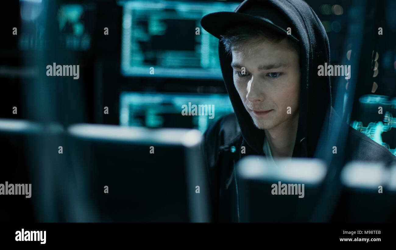 Hooded Teenage Hacker Successfully Attacks Global Infrastructure Servers with Virus. Stock Photo